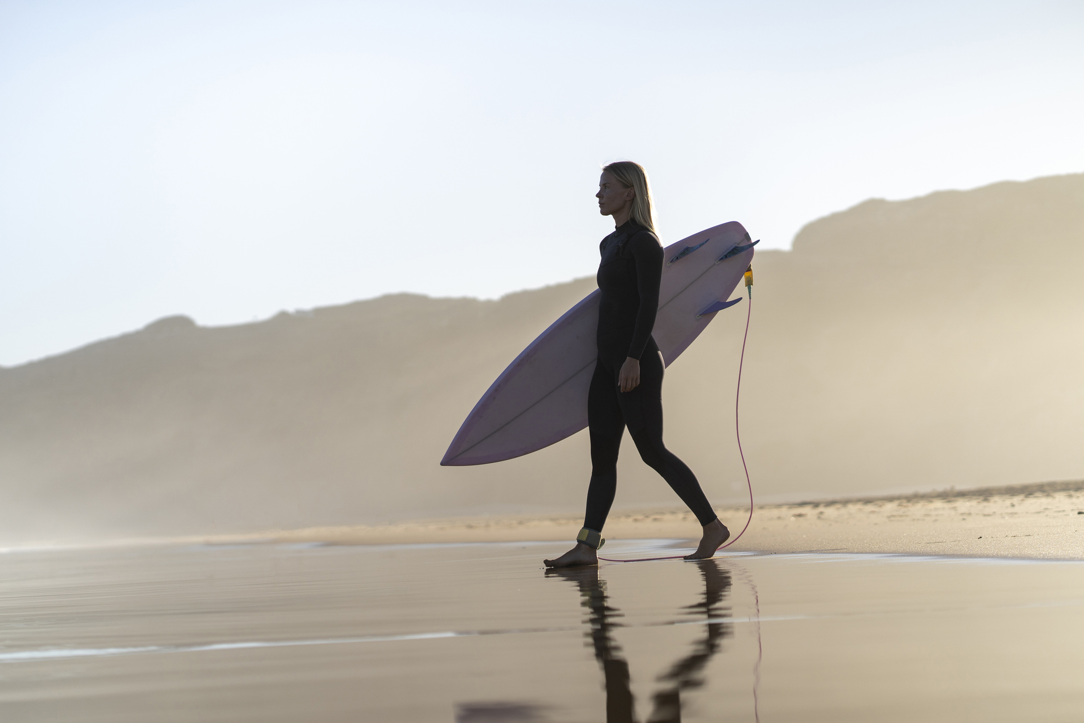 Surfer-girl-at-the-beach-at-sunrise-in-the-Algarve