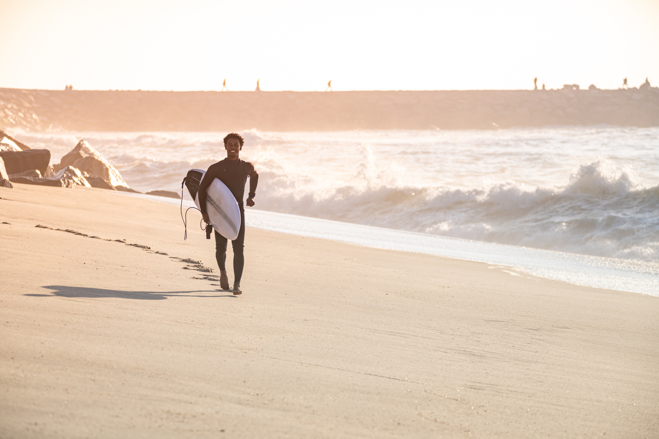 Surfer-runs-along-the-beach-in-Matosinhos